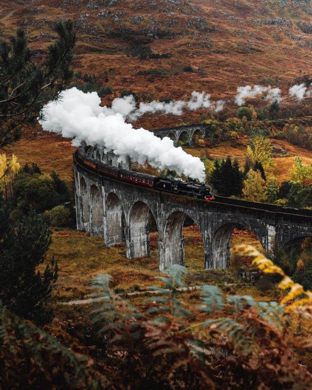Tren Jacobita de vapor recorriendo las Highlands de Escocia en un paisaje montañoso